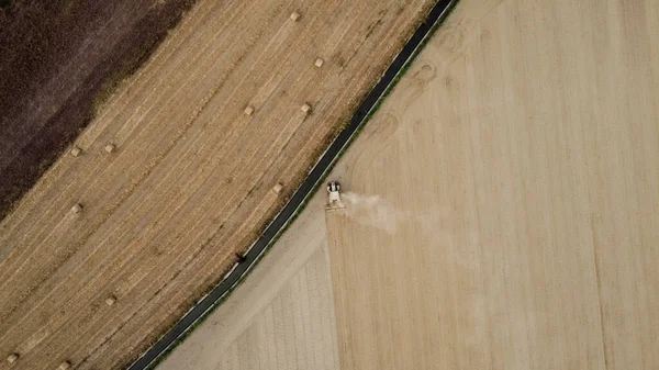 A tractor picks haystacks, top view.