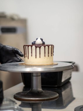 Tanınmayan bir işçi çikolatalı pasta ve dut hazırlıyor.