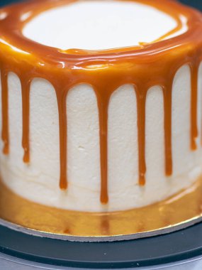 Profesyonel fırıncı çikolatalı ve kremalı pastayı tuzlu karamel ile süslüyor.