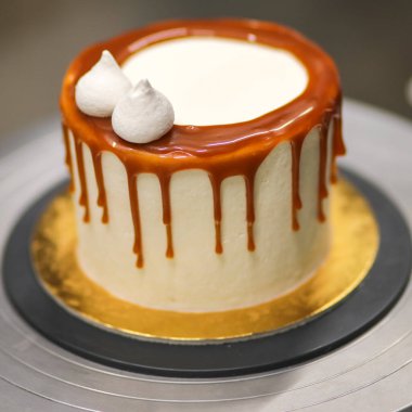 Şef kremalı pastanın üstünü dekore ediyor.