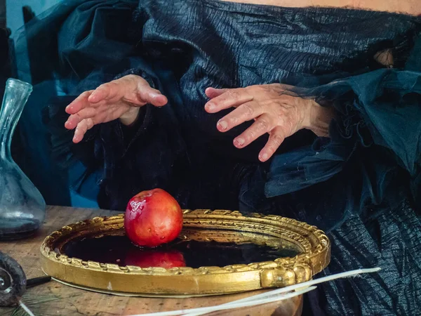 witchy preparing poisoned apple for victim as dark evil spell for halloween