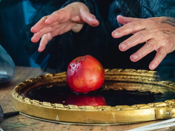 witchy preparing poisoned apple for victim as dark evil spell for halloween