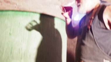 Yerel kıdemli çiftçi kırmızı şarap filtreleme evde şişeleme önce bitirme