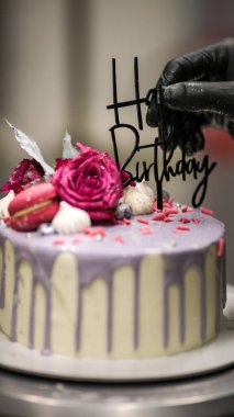 Şef usign macaron, çiçekler ve kutlama pastası için yazı.