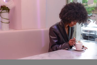 Bardaki kapuçino içen siyah model.