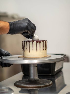 Tanınmayan bir işçi çikolatalı pasta ve dut hazırlıyor.