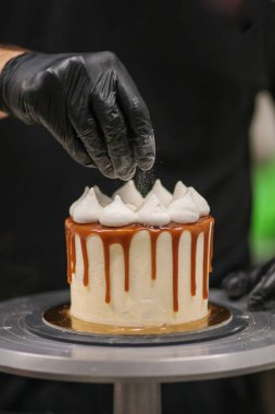 Kek tasarımcısı bir kekle iş yerinde.