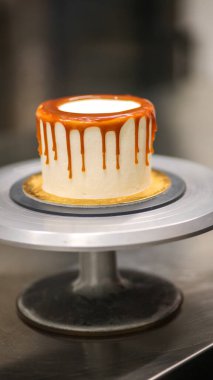 Şef kremalı pastanın üstünü dekore ediyor.