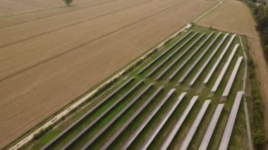 Tarım çiftliğindeki güneş panelleri temiz elektrik enerjisi yaratmak için güneş ışığıyla aydınlatılıyor.