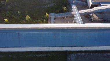 Mavi bulutlu arka planda depoları olan çimento üretim tesisinin havadan görüntüsü. Stok görüntüleri. Endüstriyel bölge ve çimento üretim fabrikasının üzerinde uçuyor.