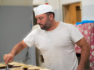 Esnaf şef tasarımcı tatlı kremalı panettone pastasını bitiriyor.