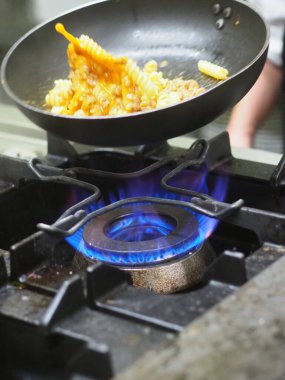 Kadın aşçı tavaya yumurta atıyor.