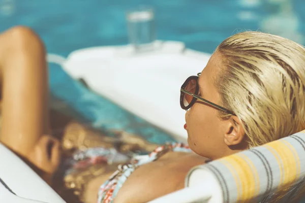 Young blonde relaxing in a pool — Stock Photo, Image