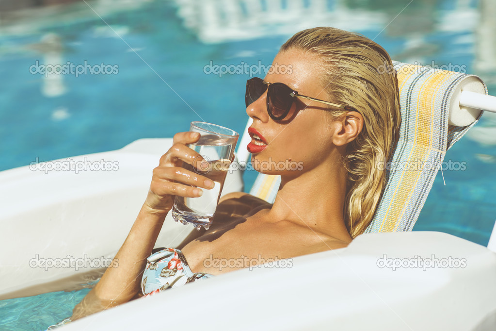 Young girl drinking water in a pool