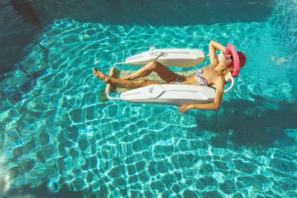 Ξανθό κορίτσι χαλαρώνοντας στην πισίνα — Stock fotografie