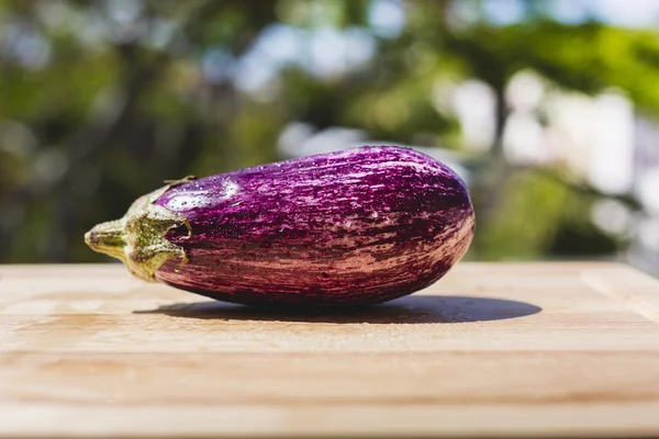 Eggplant on wooden chopping board — Stock Photo, Image