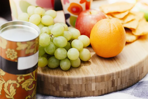 Fruits and biscuits in picnic setting — Stock Photo, Image