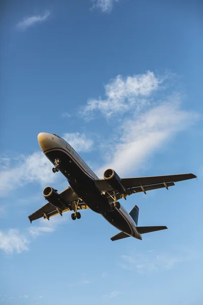 背景の青い空を飛んでいる飛行機 — ストック写真