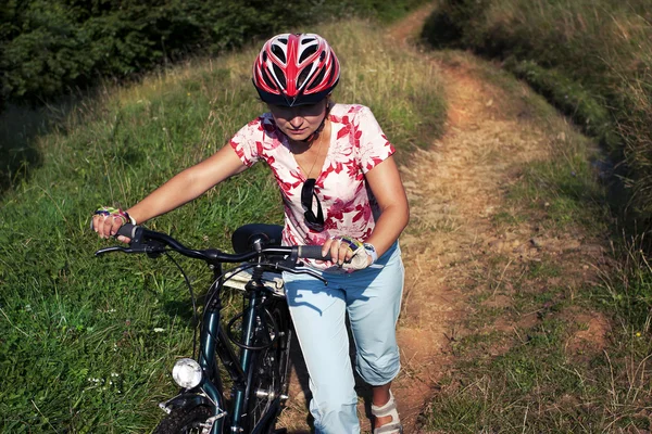 Mujer empujando la bicicleta — Foto de Stock