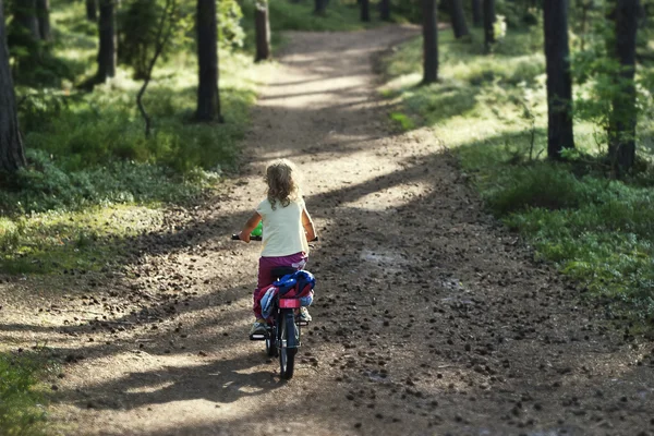 Menina andando de bicicleta na floresta — Fotografia de Stock