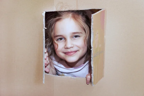 Menina dentro da casa de papelão — Fotografia de Stock