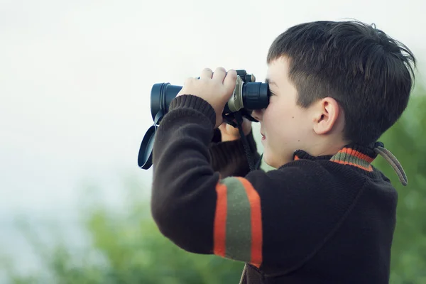 Boy looking through binocular — Stock Photo, Image