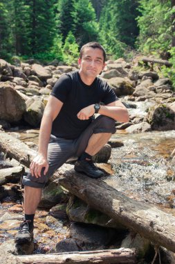 gövde üzerinde dağ yolu üzerinde oturan adam