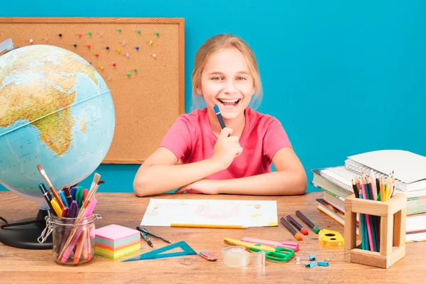 Joven chica sonriente haciendo su tarea — Foto de Stock