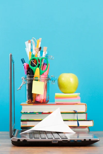 School accessories on desktop with plain blue background — Stock Photo, Image