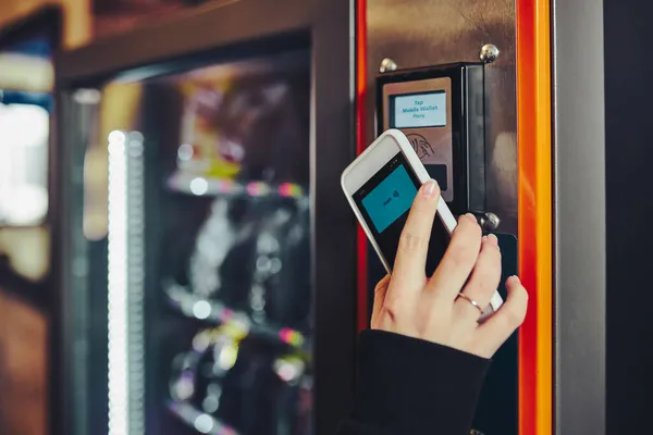 전화로 방식을 사용하여 자판기에서 제품에 비용을 지불하는 새로운 방법을 사용하는 — 스톡 사진