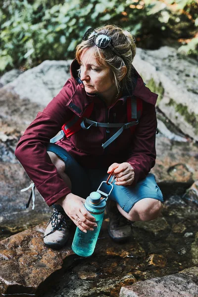 Женщина Берет Чистую Воду Бутылку Горного Ручья Время Похода Горы — стоковое фото