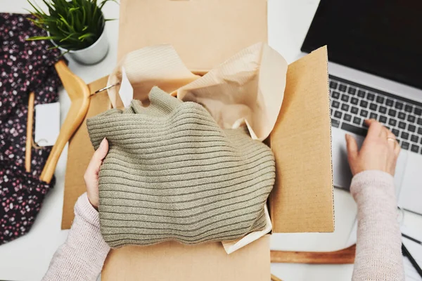 İş sahibi müşteriye çevrimiçi sipariş hazırlıyor. Çevrimiçi dükkandan giysi ürünleri paketi hazırlanıyor