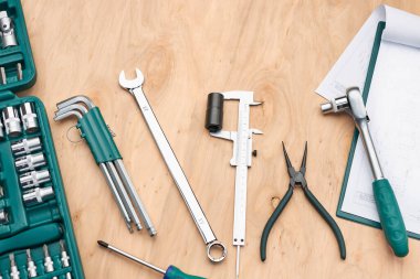 Bir sürü aletli atölye masası. İngiliz anahtarı, İngiliz anahtarı, Calliper ve cırcırböceği. İş aletleri. Evrensel alet seti. Profesyonel ekipmanlar. Arkaplan