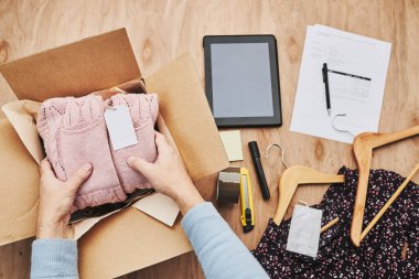 İş sahibi müşteriye çevrimiçi sipariş hazırlıyor. Çevrimiçi dükkandan giysi ürünleri paketi hazırlanıyor