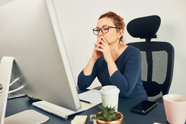 Woman entrepreneur focused on solving difficult work. Confused businesswoman thinking hard holding doccuments standing at her desk in office