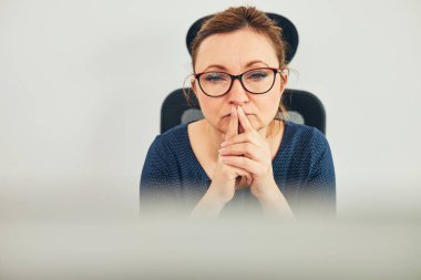 Kadın girişimci zor işleri çözmeye odaklanmıştı. Kafası karışmış bir iş kadını. Ofisindeki masasında oturmuş bilgisayar ekranına bakıyor.