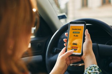 Akıllı telefondan mobil park uygulaması kullanan bir kadın. Şoför park ücretini ödemek için akıllı telefonu kullanıyor. Cep telefonundan otopark başvurusu. Çevrimiçi hızlı ödemeyle park ücretini ödemeye elverişli. Mobil park servisi