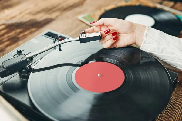 年轻女人在听黑胶唱机的音乐 在旋转唱机上播放音乐 在家里欣赏旧唱片收藏中的女歌手 一堆模拟乙烯记录 复古和复古音乐风格 音乐激情与爱好 — 图库照片