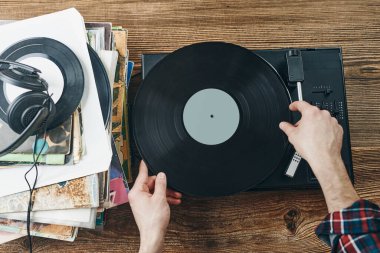 Vinil plaktan müzik dinleyen bir adam. Plak çalar üzerinde analog diskten müzik çalmak. Eski koleksiyonumdan müziğin tadını çıkarıyorum. Evde dinleniyorum. Retro ve antika. Müzik tutkusu