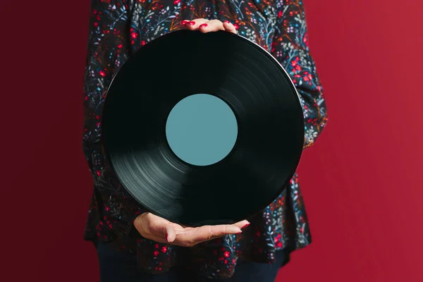 Woman holding vinyl record. Music passion. Listening to music from analog record. Playing music from analog disk on turntable player. Enjoying music from old collection. Retro and vintage. Stereo audio. Analog sound