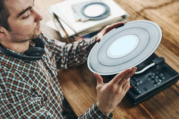 Man listening to music from vinyl record. Playing music from analog disk on turntable player. Enjoying music from old collection. Relaxing at home. Retro and vintage. Music passion