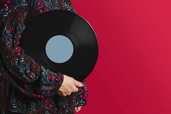 Woman holding vinyl record. Music passion. Listening to music from analog record. Playing music from analog disk on turntable player. Enjoying music from old collection. Retro and vintage. Stereo audio. Analog sound