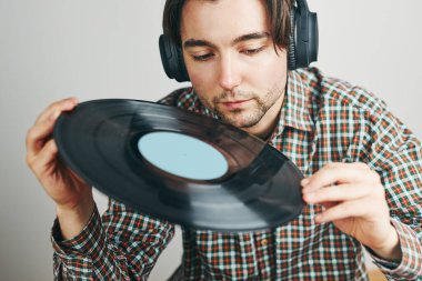Vinil plaktan müzik dinleyen bir adam. Plak çalar üzerinde analog diskten müzik çalmak. Eski koleksiyonumdan müziğin tadını çıkarıyorum. Evde dinleniyorum. Retro ve antika. Müzik tutkusu