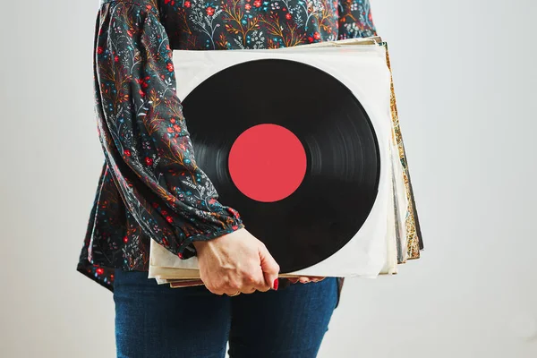 Woman holding vinyl records. Music passion. Listening to music from analog record. Playing music from analog disk on turntable player. Enjoying music from old collection. Retro and vintage. Stereo audio. Analog sound