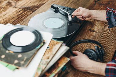Vinil plaktan müzik dinleyen bir adam. Plak çalar üzerinde analog diskten müzik çalmak. Eski koleksiyonumdan müziğin tadını çıkarıyorum. Evde dinleniyorum. Retro ve antika. Müzik tutkusu