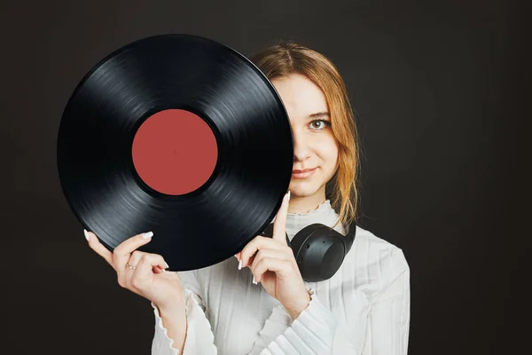 Woman holding vinyl record. Music passion. Listening to music from analog record. Playing music from analog disk on turntable player. Enjoying music from old collection. Retro and vintage. Stereo audio. Analog sound