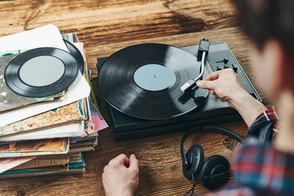 Vinil plaktan müzik dinleyen bir adam. Plak çalar üzerinde analog diskten müzik çalmak. Eski koleksiyonumdan müziğin tadını çıkarıyorum. Evde dinleniyorum. Retro ve antika. Müzik tutkusu