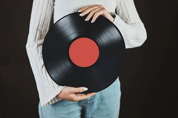 Woman holding vinyl record. Music passion. Listening to music from analog record. Playing music from analog disk on turntable player. Enjoying music from old collection. Retro and vintage. Stereo audio. Analog sound