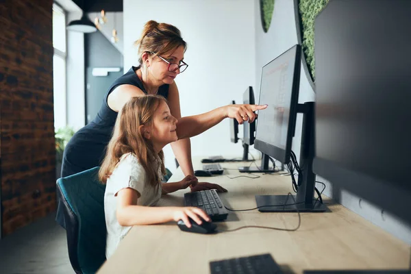 Okulda bilgisayar dersi. İlkokulda ders sırasında kız öğrenciye asistanlık yapan öğretmen. Çocuk bilgisayar bilimi dersinde bilgisayar öğreniyor. Öğretmen görev çözümü bulmaya yardım ediyor. İpucu veriyorum. Akıllı küçük kız okulda internetten öğreniyor. Çanta
