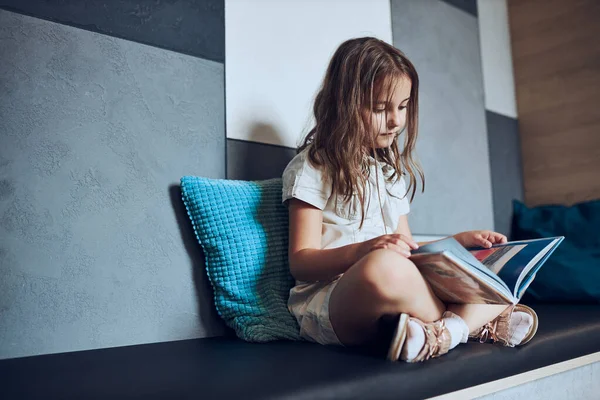 Okul kütüphanesinde kitap okuyan liseli kız. İlkokul öğrencisi kitaba bağlıdır. Ödev yapan çocuk. Akıllı kız kitaptan öğreniyor. Günlük okumanın faydaları. Çocuk merakı